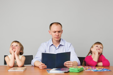 Мужчина читает детям книгу. Детям скучно. девочки...