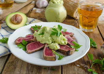 Beef steak with avocado dip and herbs
