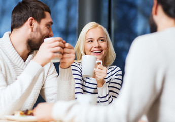 happy friends meeting and drinking tea or coffee
