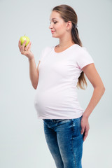 Portrait of a pregnant woman holding apple