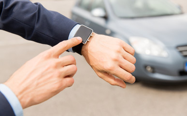 close up of male hands with wristwatch and car