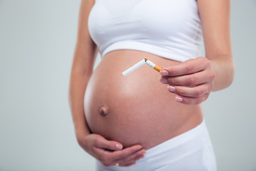 Pregnant woman breaking a cigarette