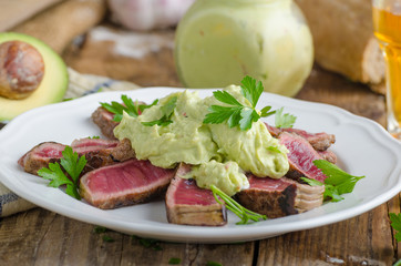 Beef steak with avocado dip and herbs