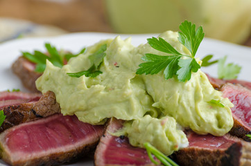 Beef steak with avocado dip and herbs