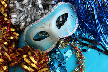 Blue carnival mask on a blue background with festive decorations