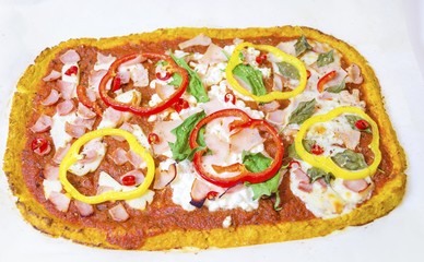 Top view of rectangular oven baked cauliflower pizza crust with halloumi,cottage,mozzarella cheese,spinach,turkey,ham,peppers,chili,basil,tomato sauce isolated on white background.A healthy snack