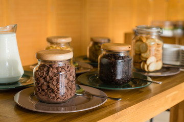 Crispy cereal, various types of glass bottles served buffet.