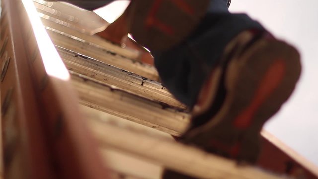 Tight Shot of Workers Climbing Up Ladder