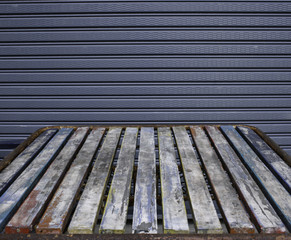 Old wooden table in front of the steel shutter door