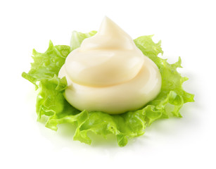Handful of mayonnaise. Swirl on green leaf. Clipping path.
