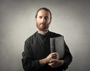 Priest holding a Bible