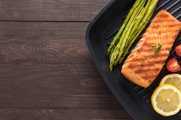  Grilled salmon cooked BBQ on a pan on wooden background © Delicious