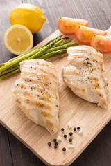 Marinated grilled chicken breasts on the wooden table
