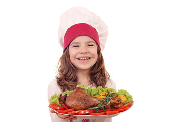 happy little girl cook with big turkey drumstick and vegetables