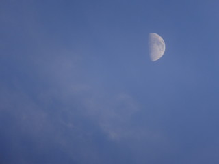 Fototapeta premium half moon in the cloudy blue sky