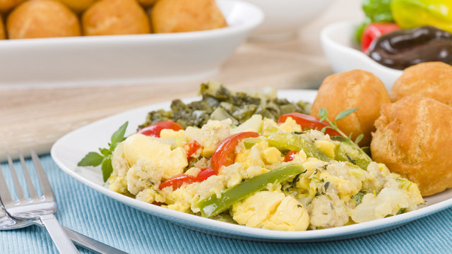 Ackee & Saltfish - Traditional Jamaican dish made of salt cod and ackee fruit. Served with callaloo and johnny cakes.
