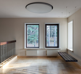 Interior of modern empty space with suspended bench and windows
