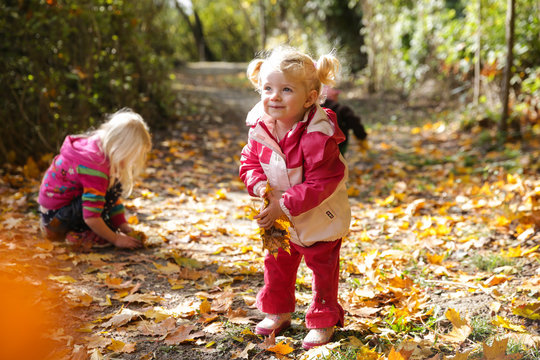 Kinder spielen mit buntem Herbstlaub