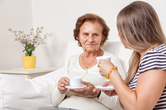 Carer Having A Cup Of Tea With An Elderly Woman