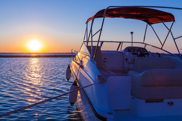 Fototapeta na wymiar Yacht near the pier against sunset