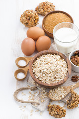 oat flakes and ingredients for making cookies on white