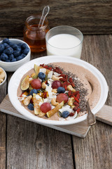 oatmeal with fruit, nuts and chia for breakfast, vertical