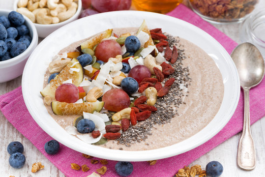 oatmeal with assorted fresh fruits, nuts and chia, closeup