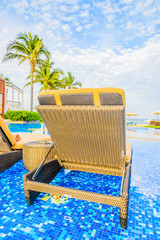 Hotel resort swimming pool with umbrella and chair on the beach