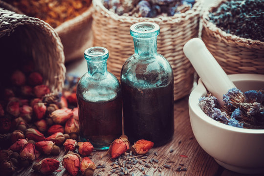 Bottles of tincture, basket with rose buds, and dried forget me