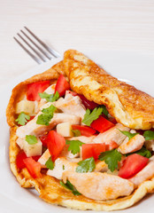 omelette with slices of chicken breast, cheese and vegetables