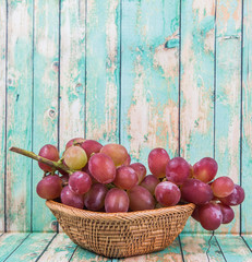 A bunch of fresh red grapes over wooden background