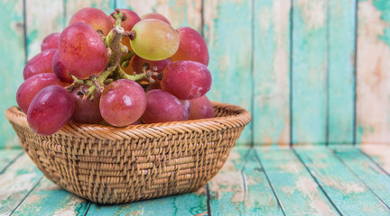 A bunch of fresh red grapes over wooden background