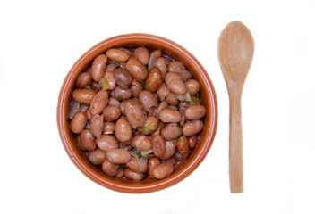 Red beans in rustic bowl on a white background seen from above