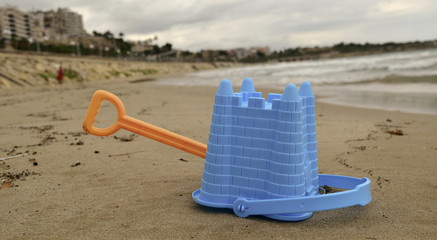 abandoned toy shovel and bucket on the beach