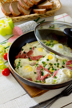 Scrambled eggs fried with sausage slices for delicious breakfast