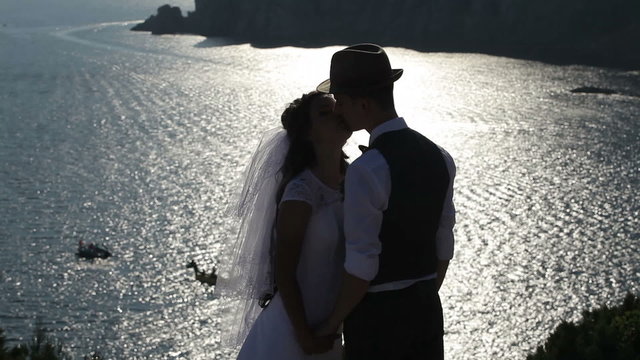  silhouette of a bride and groom on the background of the brilliant sea