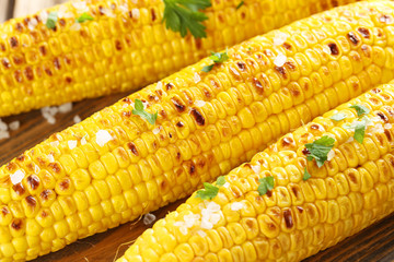 Fresh tasty grilled corn with butter on brown table