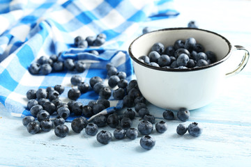 Blueberries in cup on a blue wooden background