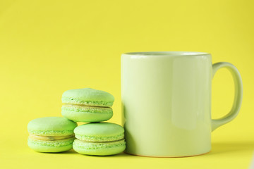 Green macarons on yellow paper background