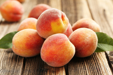 Fototapeta na wymiar Ripe peaches fruit on a brown wooden background