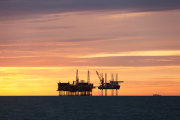 Fototapeta na wymiar Silhouette of oil platform at sunset