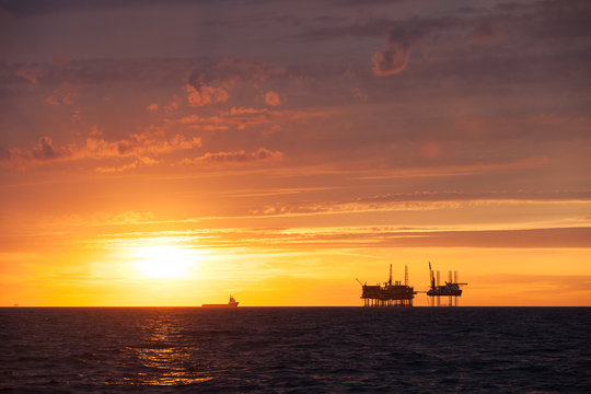 Silhouette of oil platform at sunset