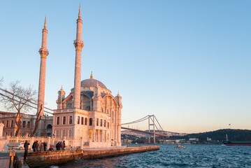 Naklejka premium The Ortakoy Mosque in Istanbul with the bridge across the Bosphorus during the sunset