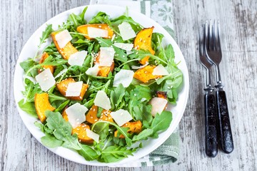 Salad with baked pumpkin, arugula, parmesan and sesame