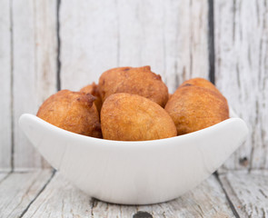 Popular Malaysian fritter snack deep fried banana balls or locally known as Cekodok Pisang in white bowl