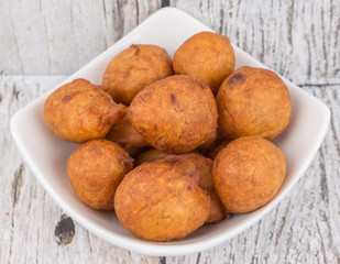 Popular Malaysian fritter snack deep fried banana balls or locally known as Cekodok Pisang in white bowl