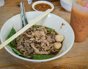 Thai Noodles with milk tea on wood table 