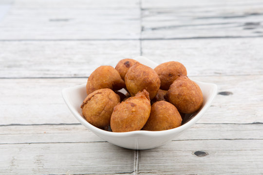 Popular Malaysian fritter snack deep fried banana balls or locally known as Cekodok Pisang in white bowl