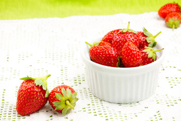Strawberries and a bowl over a lace cloth