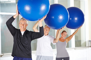 Mann beim Training mit Gymnastikball in der Reha